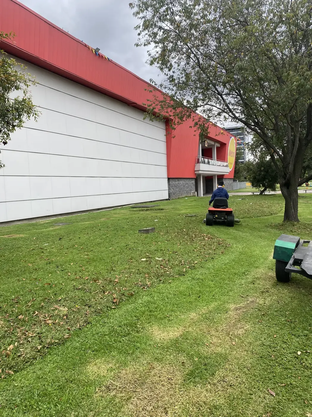 Operario de Grupo Bioingenia realizando mantenimiento de césped con maquinaria